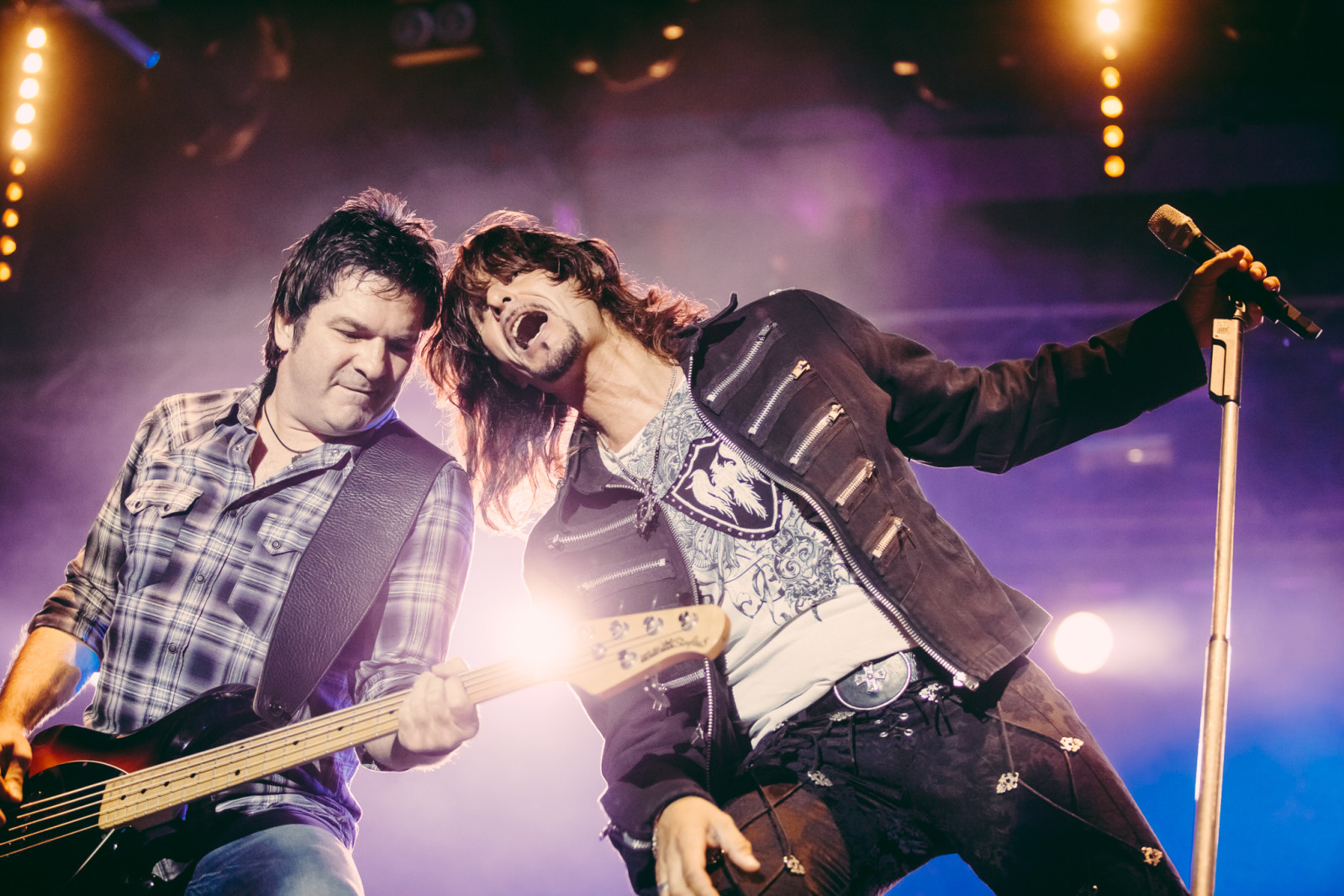 Two musicians performing under stage lights